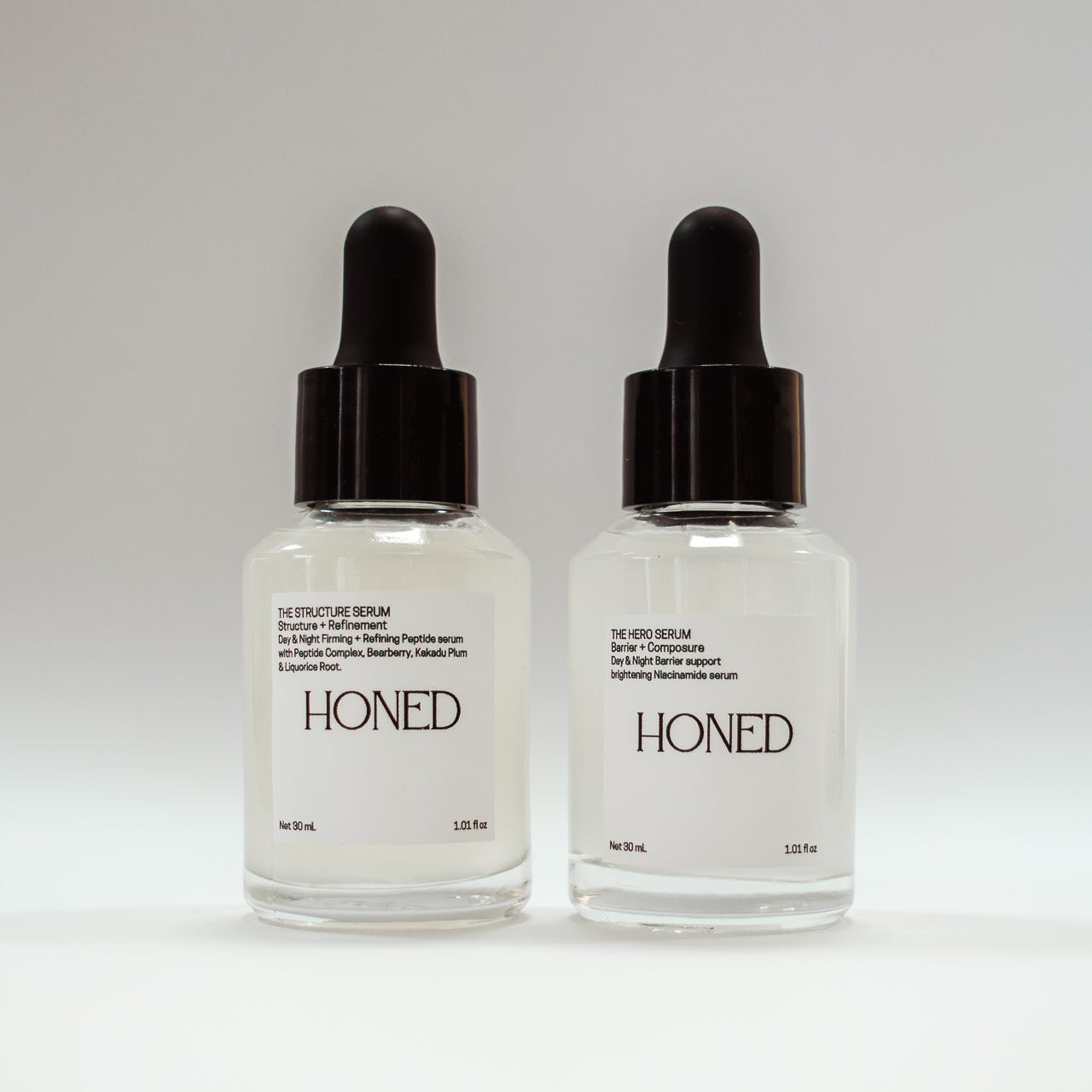 Honed peptide skincare serum and niacinamide skincare serum bottles on a white background