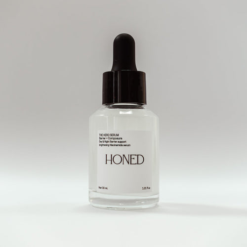 Niacinamide serum for barrier health in a glass bottle with black dropper labeled 'Honed' on a white background